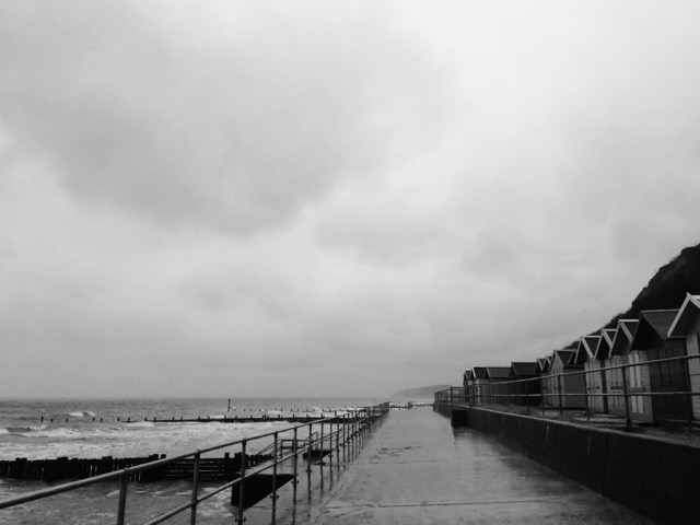 Black and white photo of the sea and beach huts